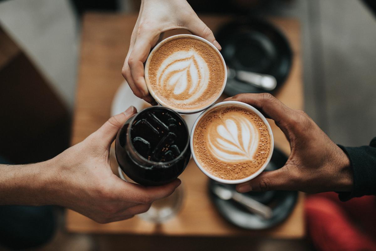 A person sipping coffee after wisdom tooth removal