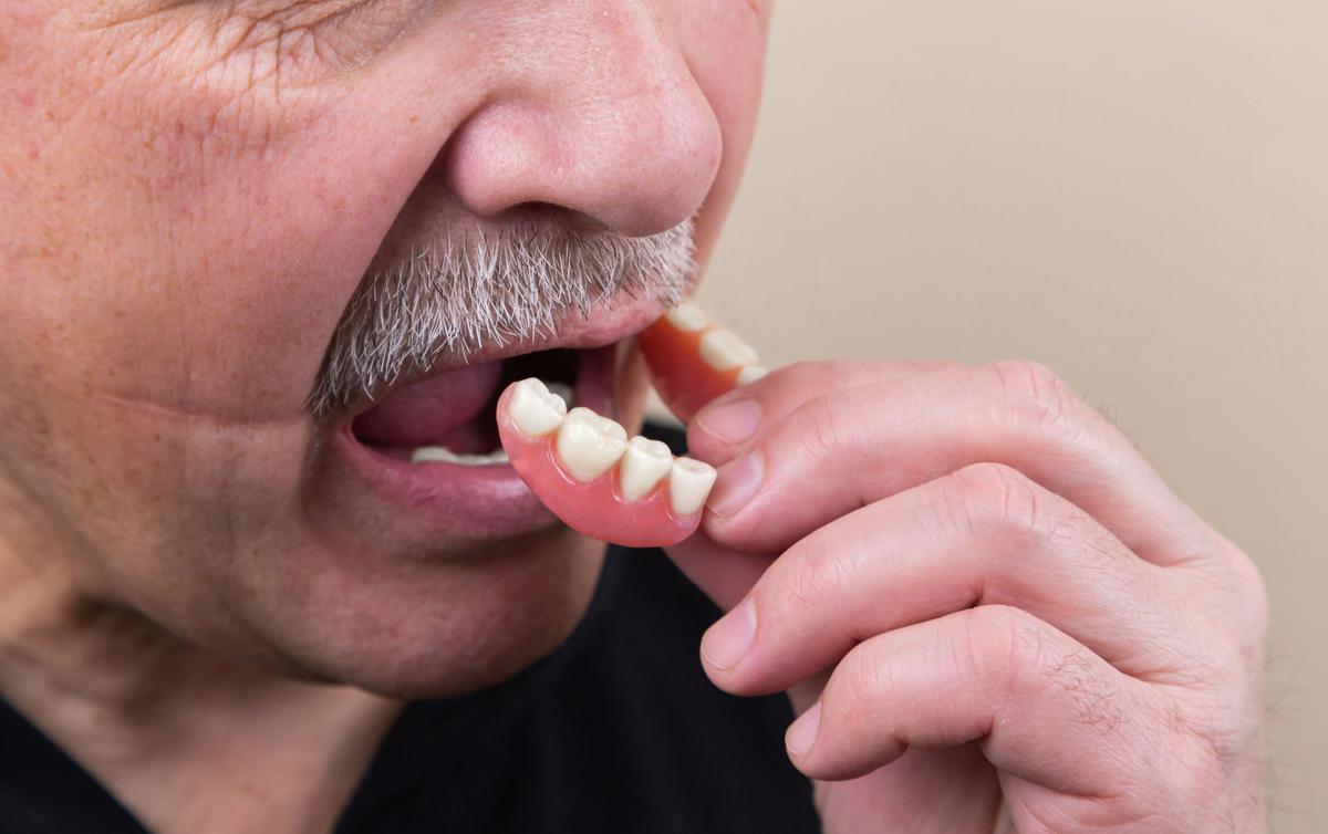 Image depicting dental cavities and a toothbrush removing dental plaque from teeth